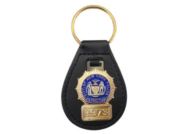 La aduana de la policía de Nueva York personalizó el llavero de cuero con el emblema suave de cobre amarillo del esmalte, oro plateado